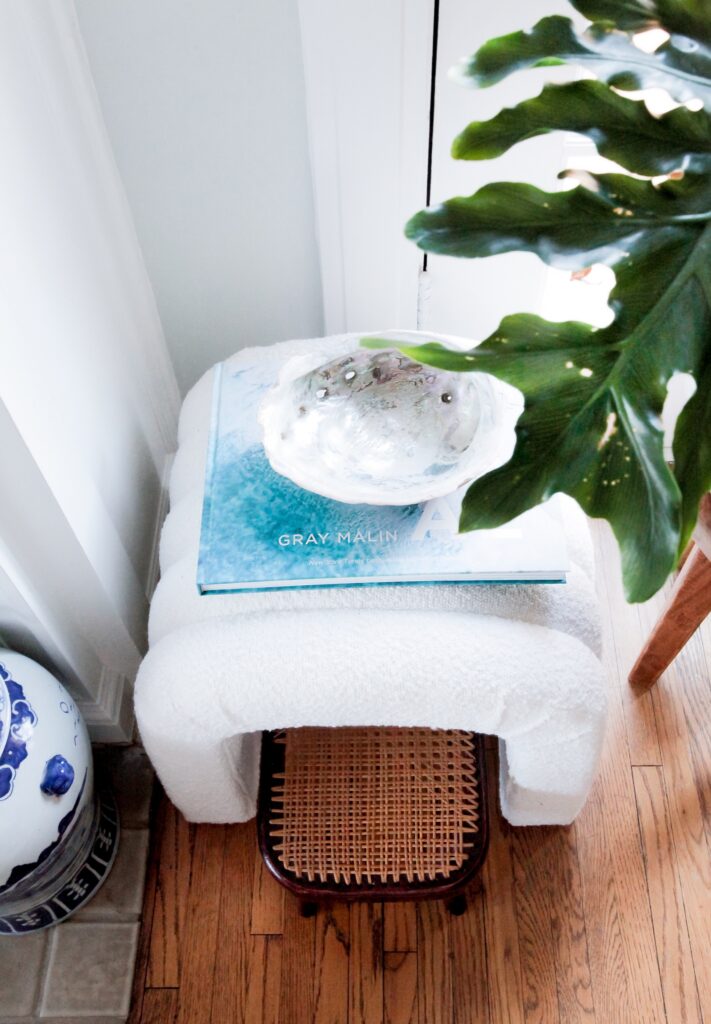 white boucle ottoman with coastal coffee table book